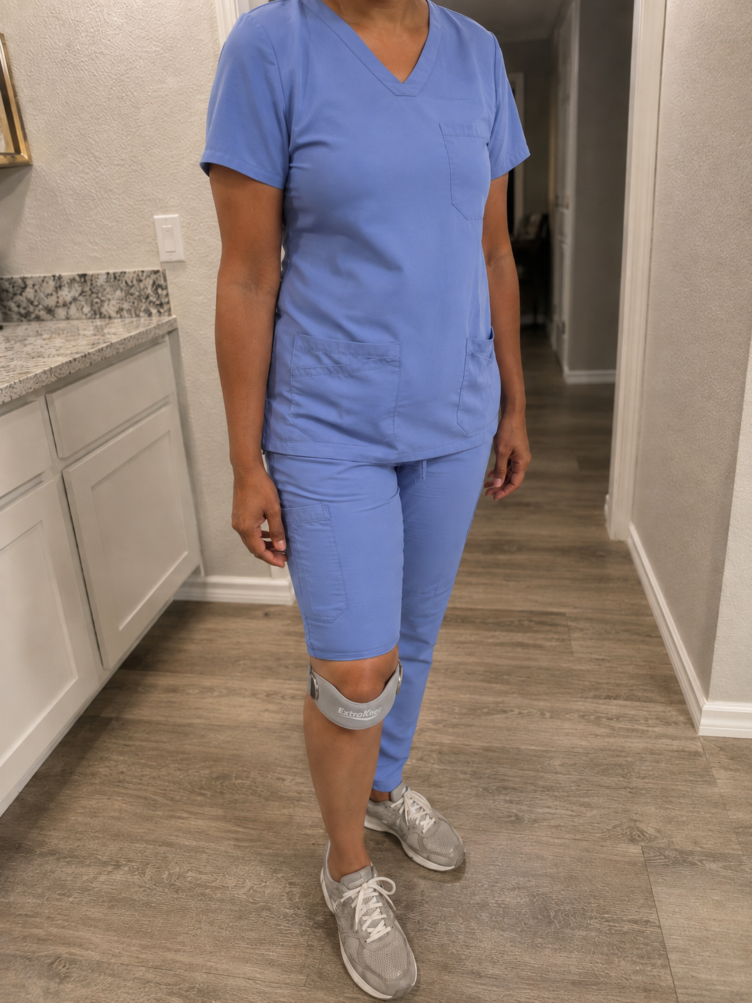 Gray ExtraKnee strap worn with medical scrubs